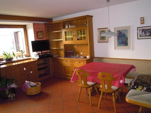 ヴァレーナにあるLuigi Apartmentのキッチン(テーブル、椅子、テレビ付)
