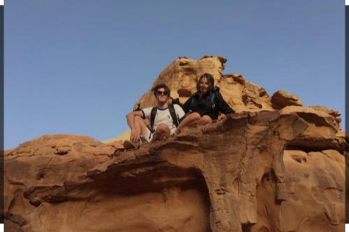 two men sitting on top of a rock formation at Dana Gardens Hotel in Dana