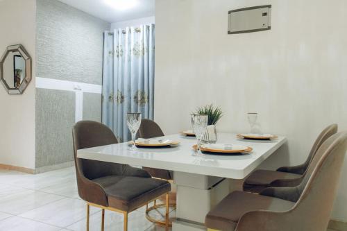jadalnia z białym stołem i krzesłami w obiekcie Stylish 2-bed Apartment Spintex w mieście Kwedonu