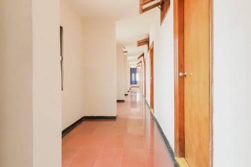 pusty korytarz z białymi ścianami i podłogą wyłożoną kafelkami w obiekcie OYO Hotel Bommana Residency w mieście Rajamandri