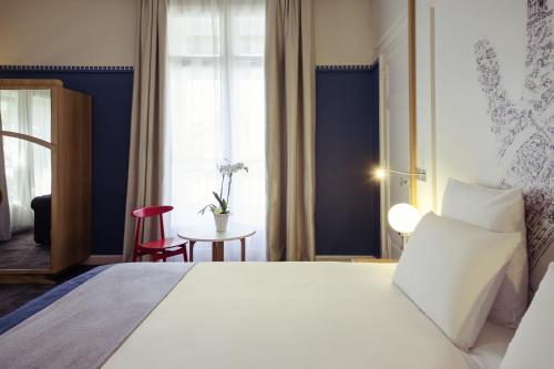 a bedroom with a large white bed and a window at Mercure Lyon Centre Château Perrache in Lyon