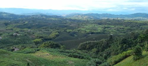 an aerial view of a green valley with mountains at Glamping Orosierra in Chinchiná