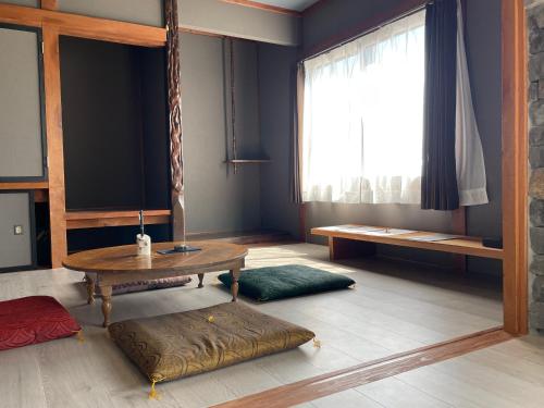uma sala de estar com uma mesa e uma janela em yadorigi（ヤドリギ） em Ikeda