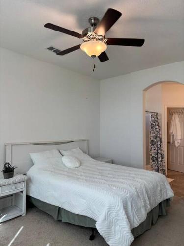 a bedroom with a ceiling fan and a bed at Cozy Comforting Home in Merced