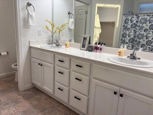 ein Badezimmer mit zwei Waschbecken und einem großen Spiegel in der Unterkunft Cozy Comforting Home in Merced