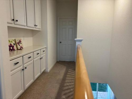 eine Küche mit weißen Schränken und einer Tür in einem Zimmer in der Unterkunft Cozy Comforting Home in Merced