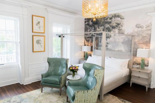una camera con letto a baldacchino, sedia e tavolo di The Harvey a New Bern