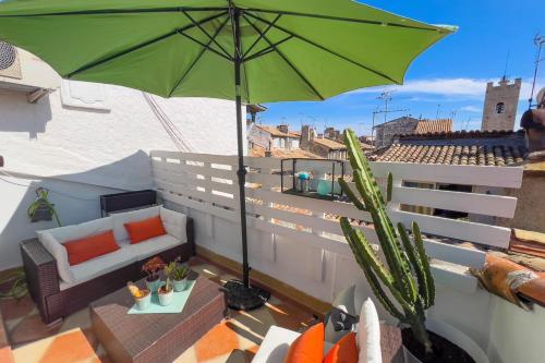 un parasol vert sur un balcon avec un canapé et une table dans l'établissement LA PLACE Apartment for 2 By Sunset, à Vence