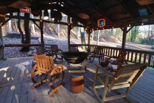 a porch with chairs and a fire pit on it at Amazing Cabin fireplace and stream #11 in Helen