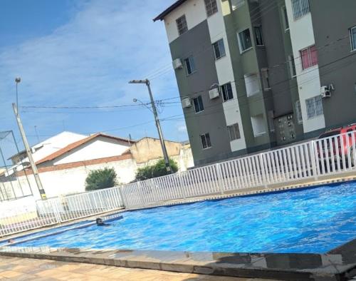 une grande piscine bleue à côté d'un bâtiment dans l'établissement Apartamento aconchegante perto do shopping, à São Luís