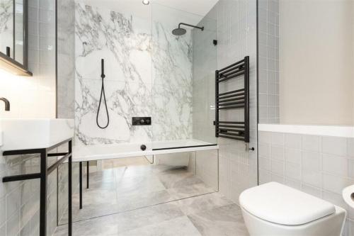 Baño blanco con lavabo y aseo en Greenwich- The O2 en Londres