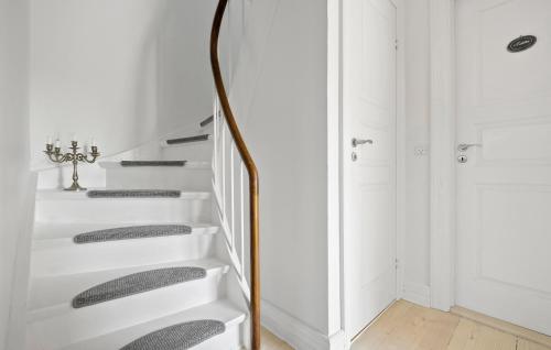 a hallway with white stairs and a mirror at 2 Bedroom Pet Friendly Home In Hornbæk in Hornbæk