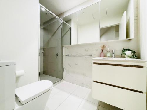 een badkamer met een douche, een toilet en een wastafel bij Mega Style Apartments Kings Domain in Melbourne