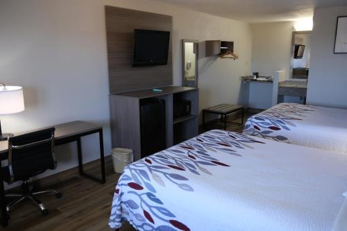 ein Hotelzimmer mit einem Bett, einem Schreibtisch und einem Computer in der Unterkunft Red Roof Inn Staunton in Staunton