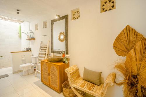 ein Wohnzimmer mit einem Spiegel und einem Stuhl in der Unterkunft Villa Deba I in Seminyak