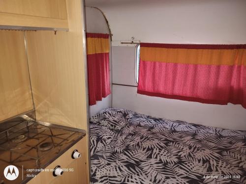 a small bedroom with a bed and a window at Casa Rodante en granja in Santiago del Estero