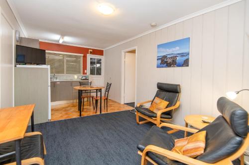 a living room with a table and chairs and a kitchen at Cascade Garden Apartments in Burnt Pine