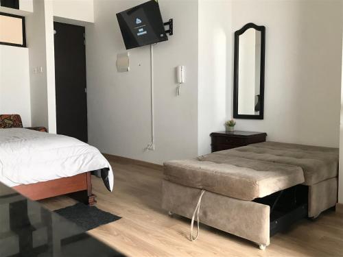 Schlafzimmer mit einem Bett und einem Wandspiegel in der Unterkunft Apartamento en La Candelaria, centro histórico Bogotá in Bogotá