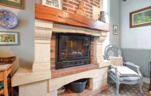 a living room with a brick fireplace at Cozy Home In Saint-Pierre-En-Auge in Sainte-Marguerite-de-Viette