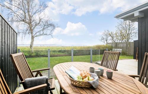 a wooden table with a basket of fruit on a patio at 2 Bedroom Nice Home In Vordingborg in Vordingborg