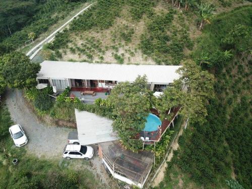 une vue aérienne sur une maison avec une voiture garée devant dans l'établissement Glamping Orosierra, à Chinchiná