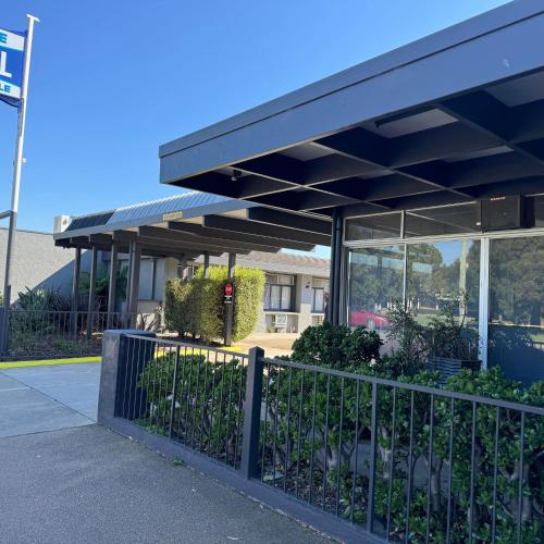 a building with a fence in front of it at Castle Motel Bairnsdale in Bairnsdale