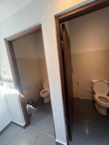 two toilets in a bathroom with two stalls at Dream Beach Hostel Lembongan in Nusa Lembongan
