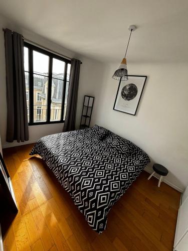une chambre avec un lit et une grande fenêtre dans l'établissement Location exclusive pour les jeux olympiques de Paris et Roland Garros, à Boulogne-Billancourt