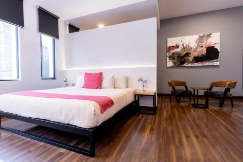 1 dormitorio con 1 cama, mesa y sillas en Urban Grupo Amber - Collection O en Puebla