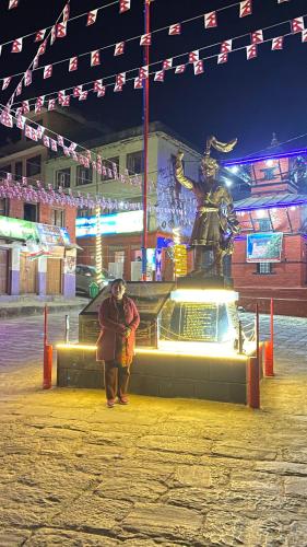 a woman standing in front of a statue of a samurai at Gorkha Chhen bed & breakfast in Gorkhā