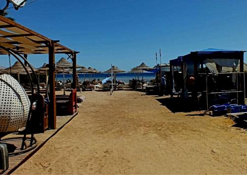 a beach with umbrellas and chairs on the sand at Sharm Hills Resort in Sharm El Sheikh