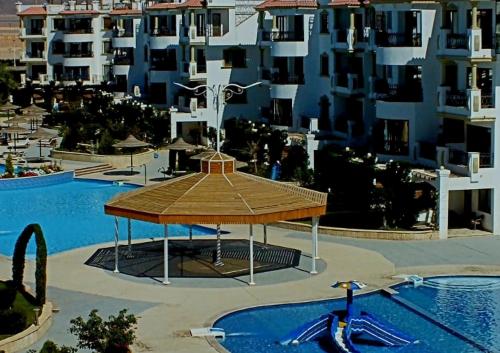 a swimming pool with a gazebo in front of some buildings at Sharm Hills Resort in Sharm El Sheikh