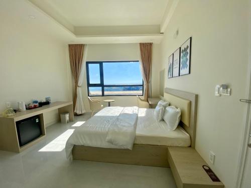 ein Schlafzimmer mit einem großen Bett und einem großen Fenster in der Unterkunft Island Sunset Hotel - Đảo Phú Quý in Cu Lao Thu