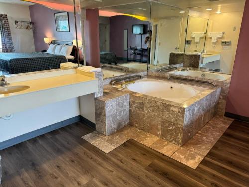 a large bathroom with a tub and a bedroom at Express Inn-Rahway in Rahway