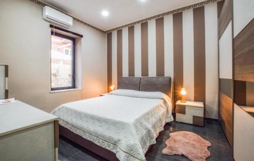- une chambre avec un lit et un mur rayé dans l'établissement 2 Bedroom Awesome Home In Mitogio, à Gaggi