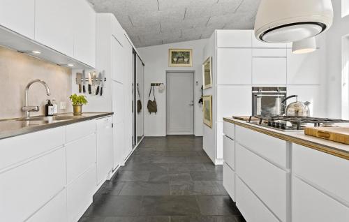 Bedsted ThyにあるStunning Home In Bedsted Thy With Wifiの白いキャビネットと長い廊下付きのキッチン