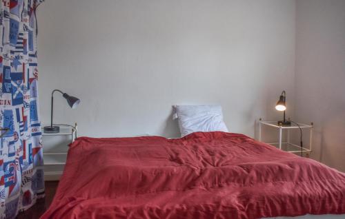 a bedroom with a red blanket on a bed at Beautiful Home In Ystad With Kitchen in Ystad
