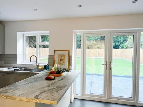 - une cuisine avec un comptoir en marbre et des portes coulissantes en verre dans l'établissement 4 Bedroom House Coventry Sleep 7 with 3 Parking Spaces, à Coventry