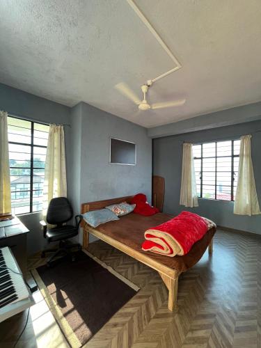 um quarto com uma cama, uma cadeira e janelas em Kito Homestay 