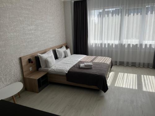 a bedroom with a bed and a large window at Apart Elite in Bălţi