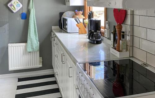 a kitchen with white cabinets and a counter top at 2 Bedroom Stunning Home In Bergkvara in Bergkvara