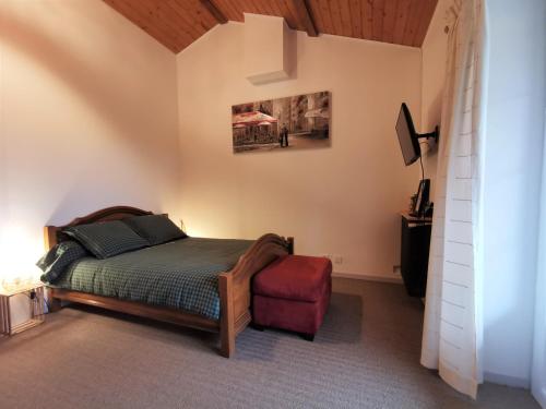 1 dormitorio con cama y taburete rojo en Évasion Romantique: Terrasse Privée, Bain Norvégien, et Table d'Hôtes – Bien-être à 1h de Lyon - FR-1-582-474, en Monistrol-sur-Loire
