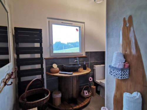 Un baño de juguete con lavabo y ventana. en Évasion Romantique: Terrasse Privée, Bain Norvégien, et Table d'Hôtes – Bien-être à 1h de Lyon - FR-1-582-474, en Monistrol-sur-Loire