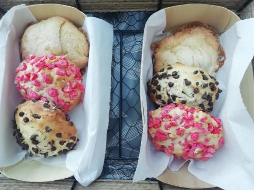 trois muffins dans une boîte sur une table dans l'établissement Évasion Romantique: Terrasse Privée, Bain Norvégien, et Table d'Hôtes – Bien-être à 1h de Lyon - FR-1-582-474, à Monistrol-sur-Loire