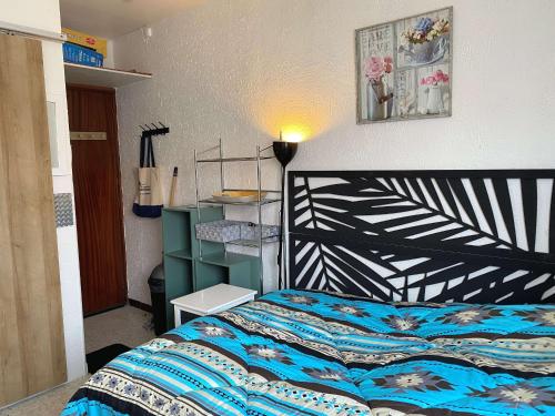 une chambre avec un lit avec une couette bleue dans l'établissement Studio cosy à 5 min des Thermes avec lave-linge, proche commerces - Balaruc-les-Bains - FR-1-553-257, à Balaruc-les-Bains