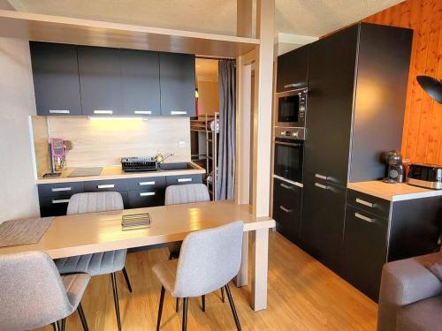 une cuisine avec une table et des chaises dans une pièce dans l'établissement Grand studio rénové, confort moderne, balcon sud, proche ski et randonnées - FR-1-393-172, à Saint-Michel-de-Chaillol