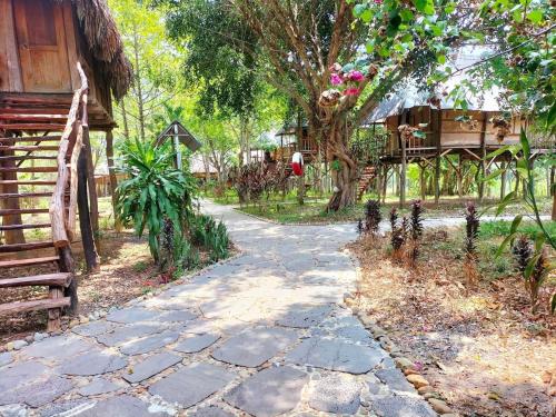 a stone walkway in front of a house at Du Nam Riverside Tour Trọn Gói in Tân Phú