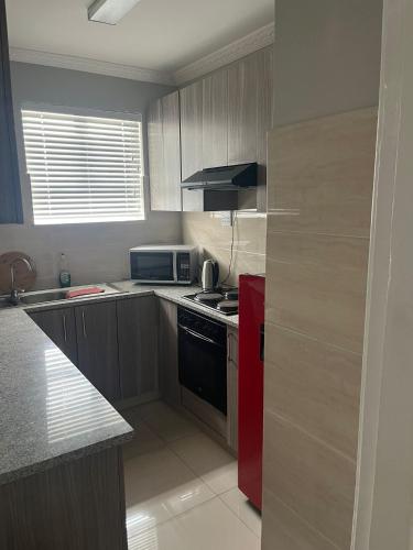 a kitchen with a red refrigerator and a stove at 10 Glen Court in Durban