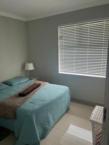 a bedroom with a bed and a large window at 10 Glen Court in Durban
