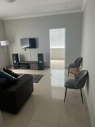 ein Wohnzimmer mit einem Sofa und einem Stuhl in der Unterkunft 10 Glen Court in Durban